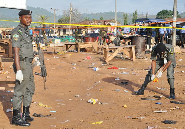 Policiais nigerianos investigam localidade perto de Abuja onde Boko Haram cometeu atentado. Crédito Gbenga Olamikan - 3.out.2015/Associated Press